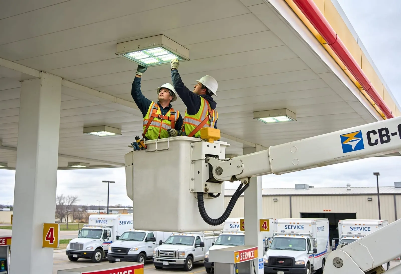 Gas station lighting regional rollout: multiple service trucks at LED canopy retrofit
